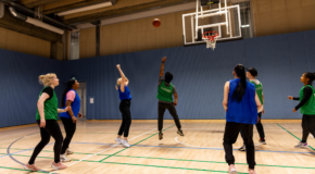 People playing basketball at a sport hall.