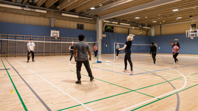 opiskleijat pelaamassa sulkapalloa liikuntasalissa